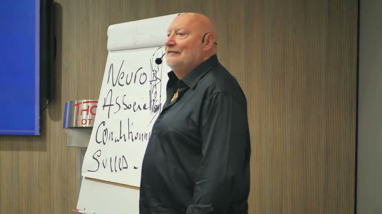 Roger Lannoy devant un tableau consacré au conditionnement neuro-associatif