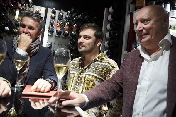 Roger Lannoy partageant une coupe de champagne avec des participants