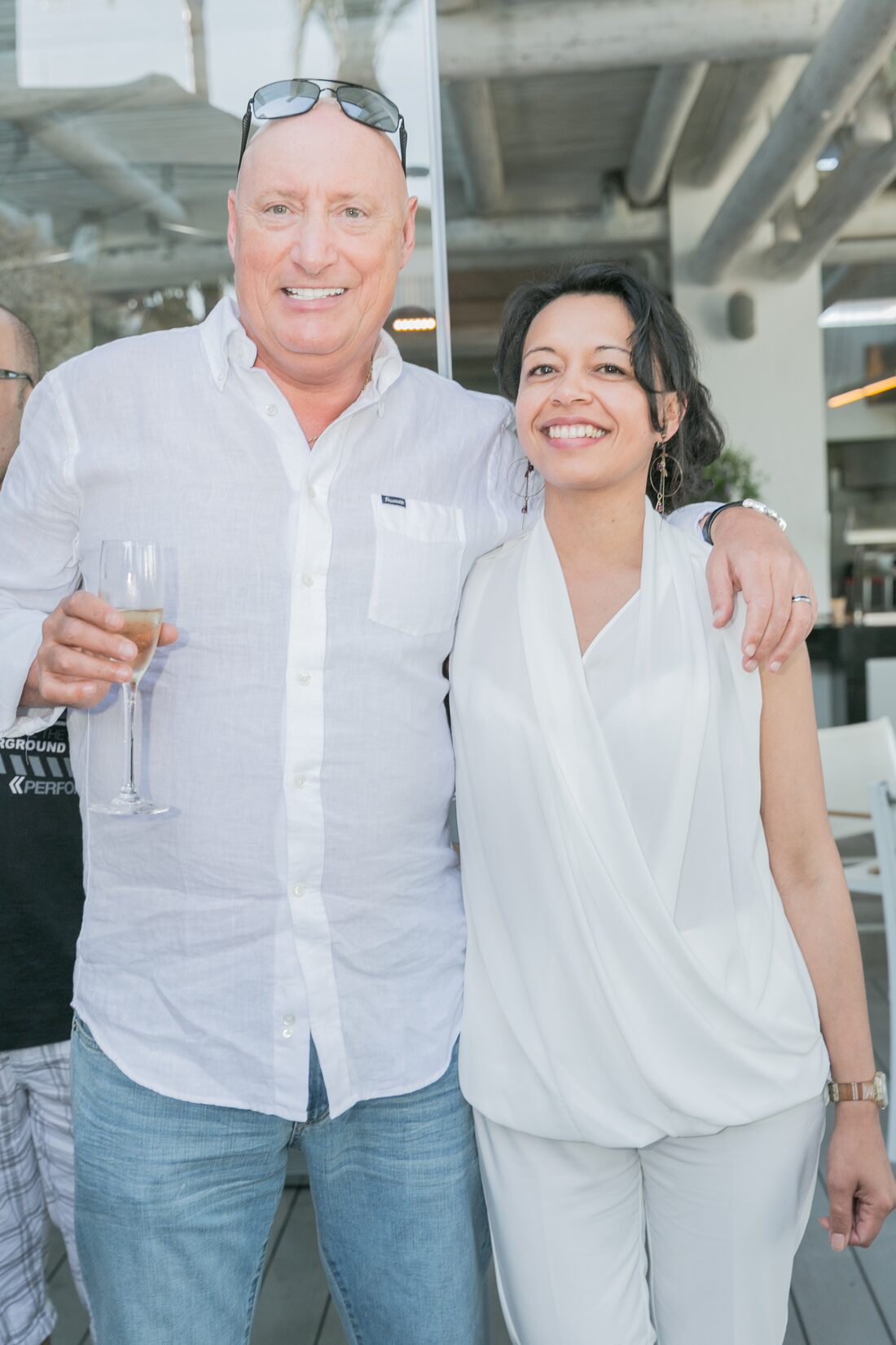 Roger Lannoy, une coupe de champagne à la main, avec une participante